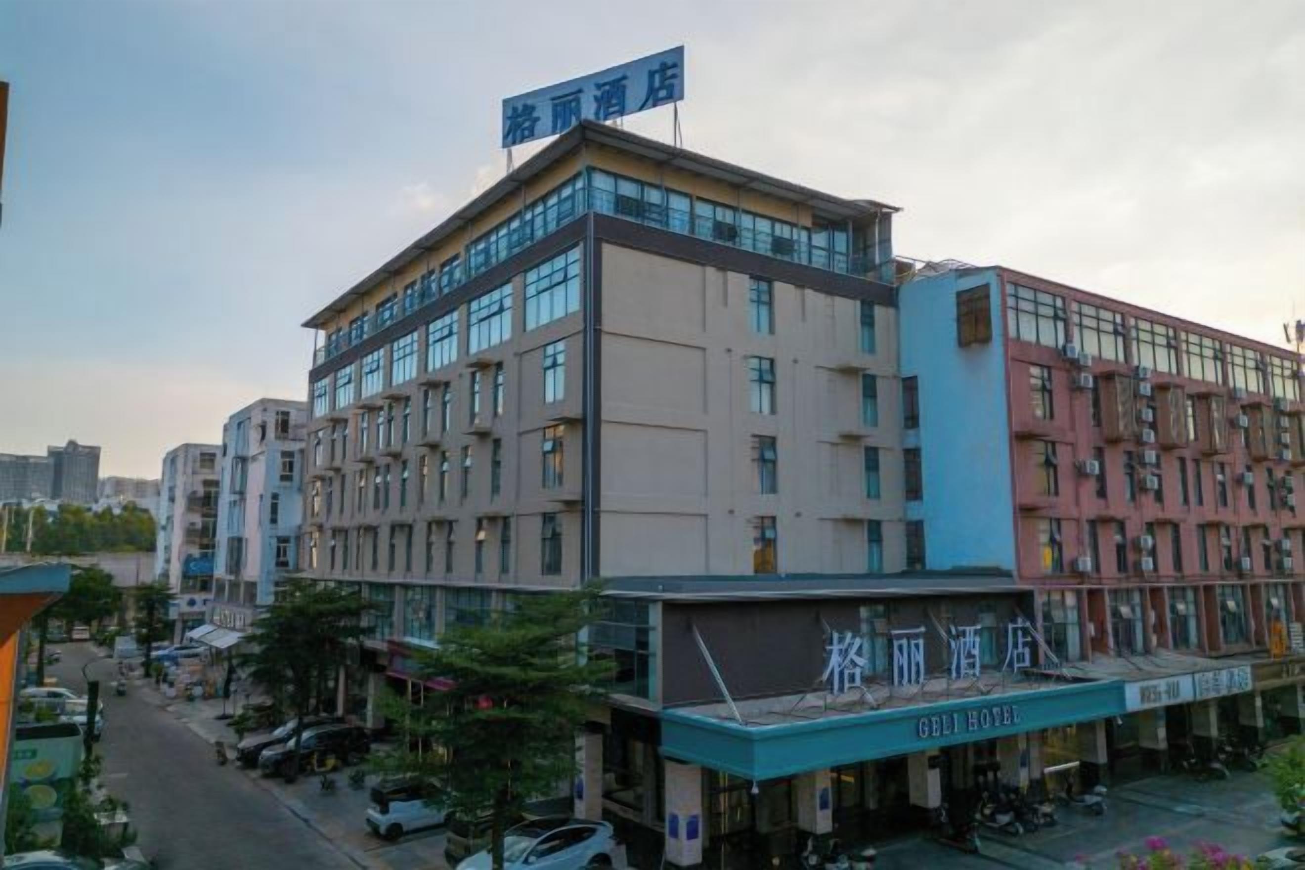 A multi-story hotel with a prominent sign, a ground-level restaurant, and a parking area.