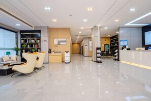 A modern hotel lobby with a reception desk, seating area, and a large window. - GELI Hotel (Guigang High-speed Railway Station Shenghuogang) (Guigang)