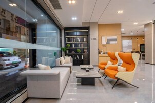 Un interior moderno con una zona de estar, una estantería y un televisor.