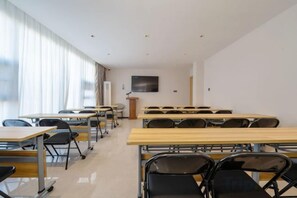 A classroom with rows of desks and chairs, a podium, and a large window with curtains. - GELI Hotel (Guigang High-speed Railway Station Shenghuogang) (Guigang)