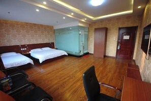Habitación de hotel con dos camas, un escritorio, una silla y un divisor de vidrio.