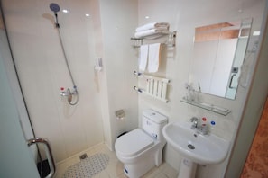 Un baño moderno con ducha, inodoro y lavamanos.