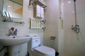 Un baño con lavamanos, inodoro y ducha.