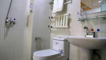 A bathroom with a toilet, sink, and shower.