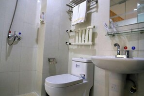 Un baño con inodoro, lavabo y ducha.