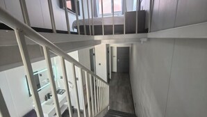 A staircase with white railings leading to a bedroom with a bed and a window. - Richmond Holiday Hotel (Qinhuangdao Shanhaiguan Laolongtou Resort) (Qinhuangdao)