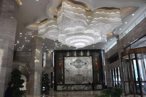 A spacious lobby with a large chandelier, marble wall, and a staircase. - Chiping Hotel (Liaocheng)