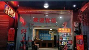 Une devanture de magasin avec une enseigne au néon, un comptoir d’accueil et divers articles exposés.
