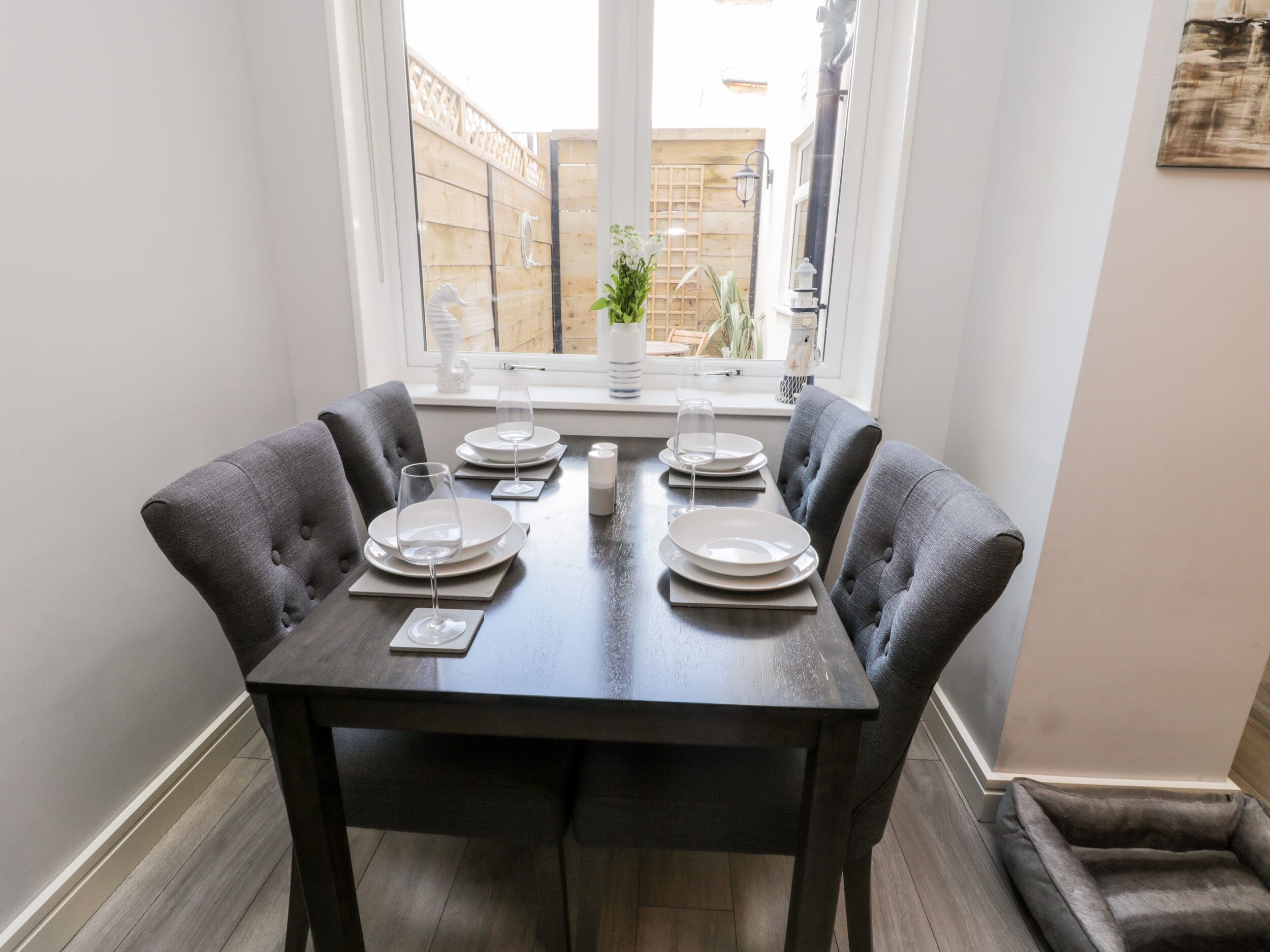 A dining table set for six with plates, glasses, and cutlery.