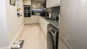 A modern kitchen with stainless steel appliances, a built-in oven, and a dishwasher. - North Bay Retreat (Scarborough)