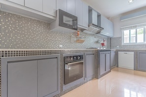 Enjoy cooking in this well-equipped kitchen with a stainless steel oven, microwave, and mosaic backsplash.