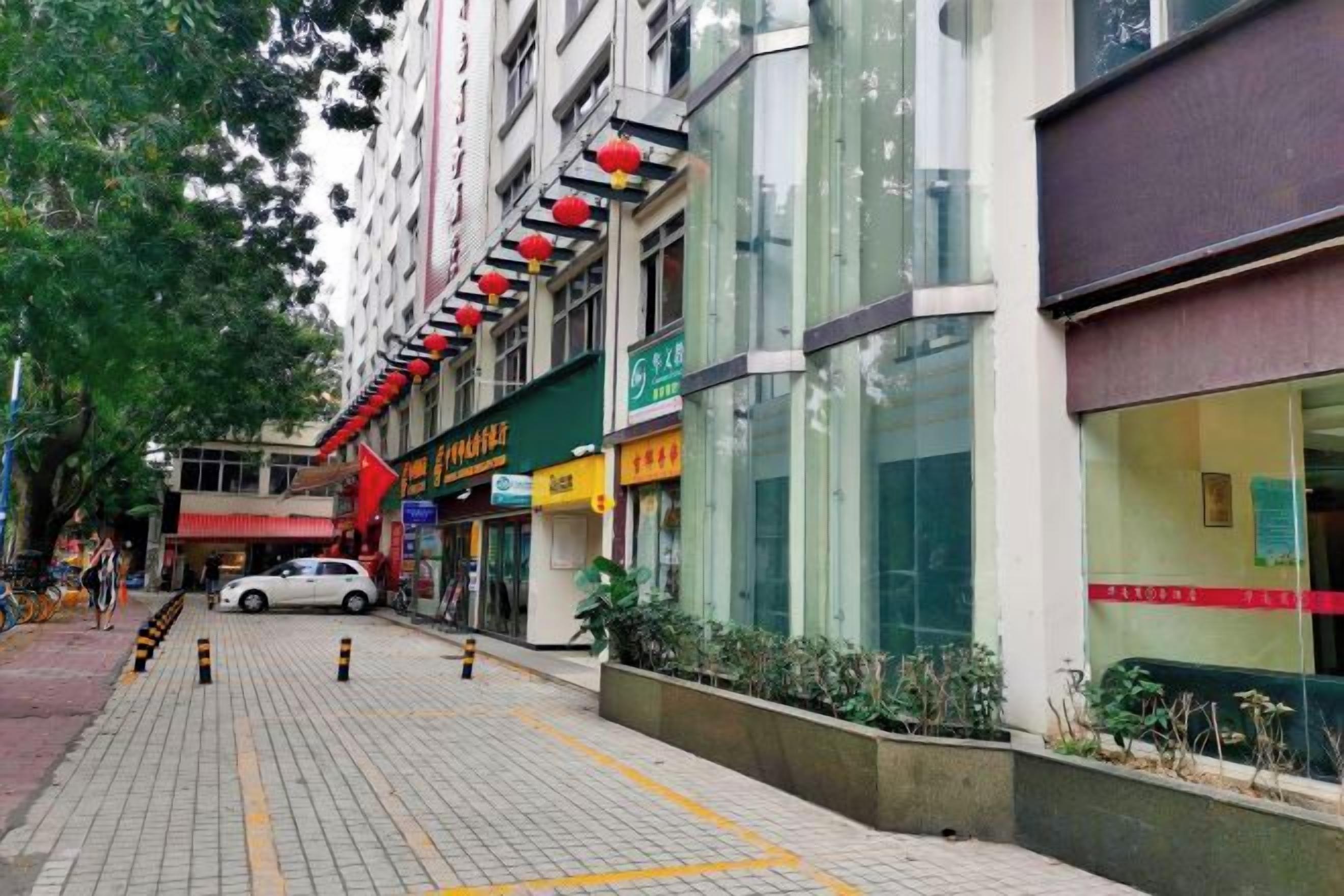Une rue de la ville avec des devantures de magasins, un trottoir pour les piétons et une voiture garée.