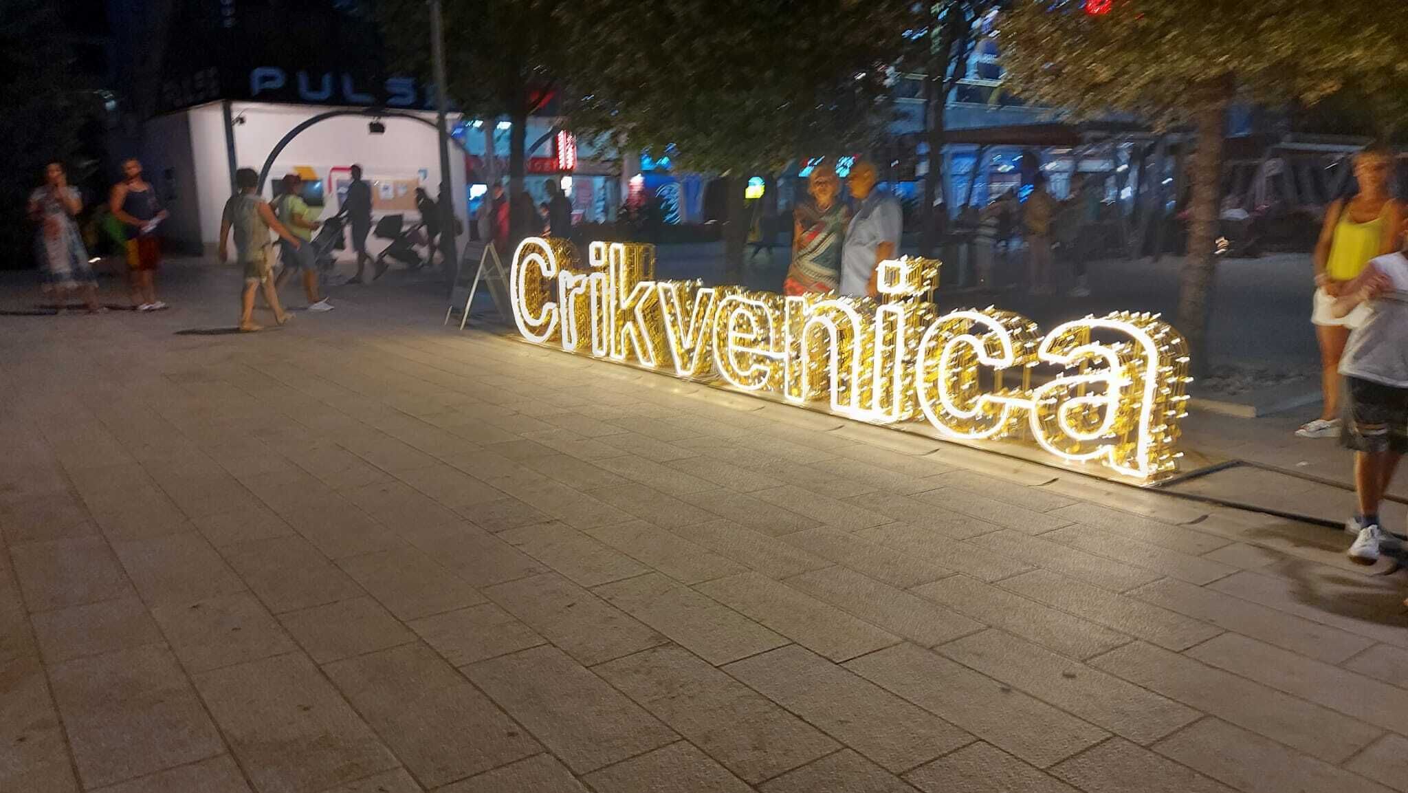 Uma placa bem iluminada com a palavra 'Crkvenica' em letras grandes e iluminadas.