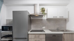 A modern kitchen with a built-in microwave, a stainless steel refrigerator, and a dishwasher. - Villa Dubravka A (Crikvenica)