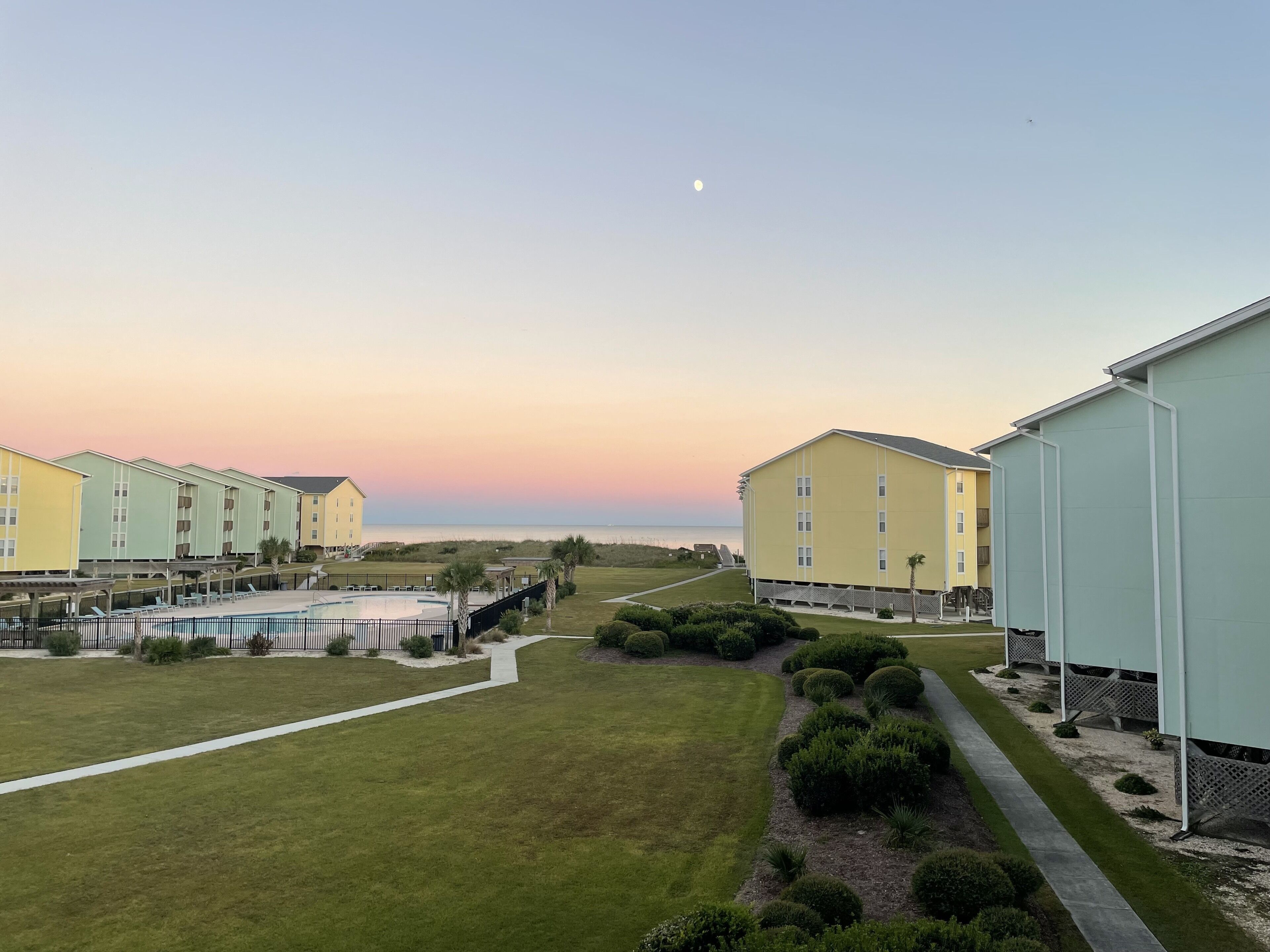 Een resort met meerdere gebouwen, een zwembad en een keurig onderhouden gazon.