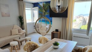 Ett modernt vardagsrum med en soffa, ett matbord och en hängstol.