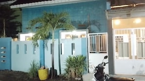 A residential building with a blue exterior, a gated entrance, and a parked scooter. - 999 KHS Homestay (Banyuwangi)