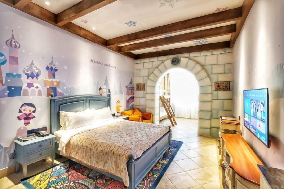 Ein Schlafzimmer mit einem Bett, einem Nachttisch, einem Fernseher und einem Wandgemälde.
