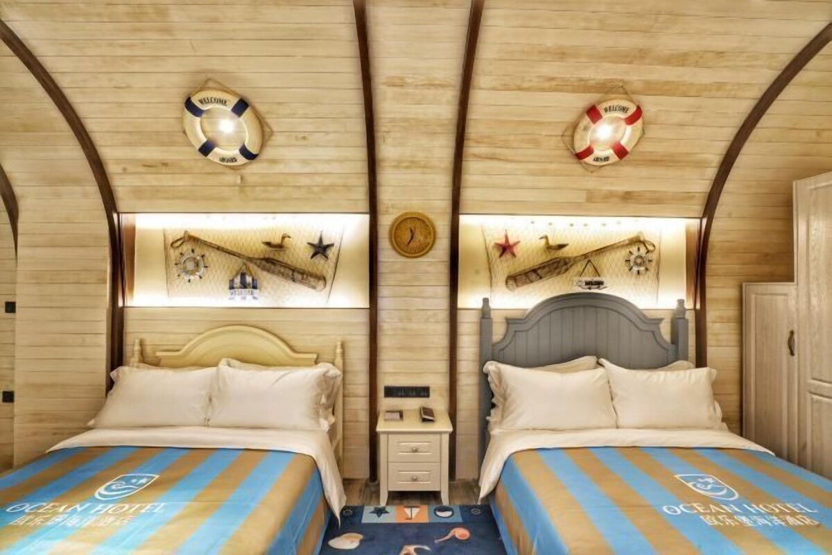 Ein Zimmer mit zwei Betten, Holzwänden, Rettungsringen und maritimer Dekoration.