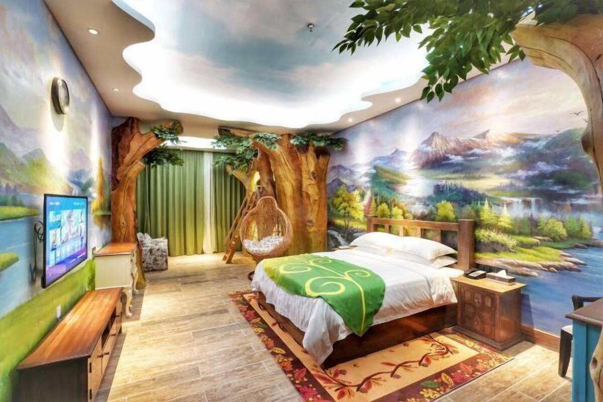 Ein Schlafzimmer mit Bett, Fernseher, einer Hängesessel und einem Wandbild einer Landschaft.