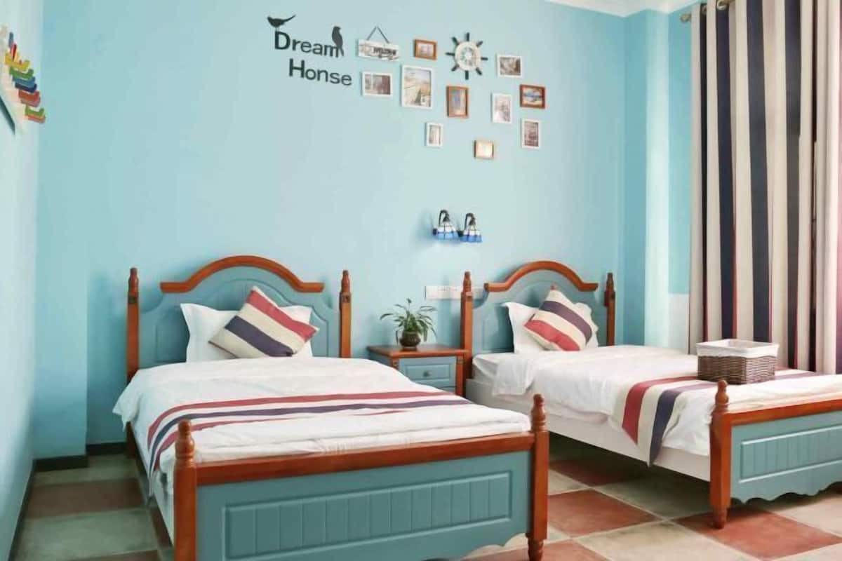 A room with two beds, a clock, framed pictures, and a sign that says "Dream Horse".