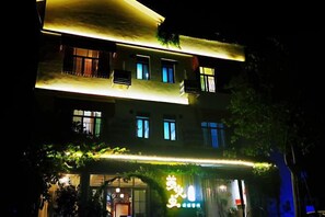 A multi-story building with illuminated signage and windows, suggesting a commercial or hotel property. - Danxia Firefly Boutique Inn (Renhua)