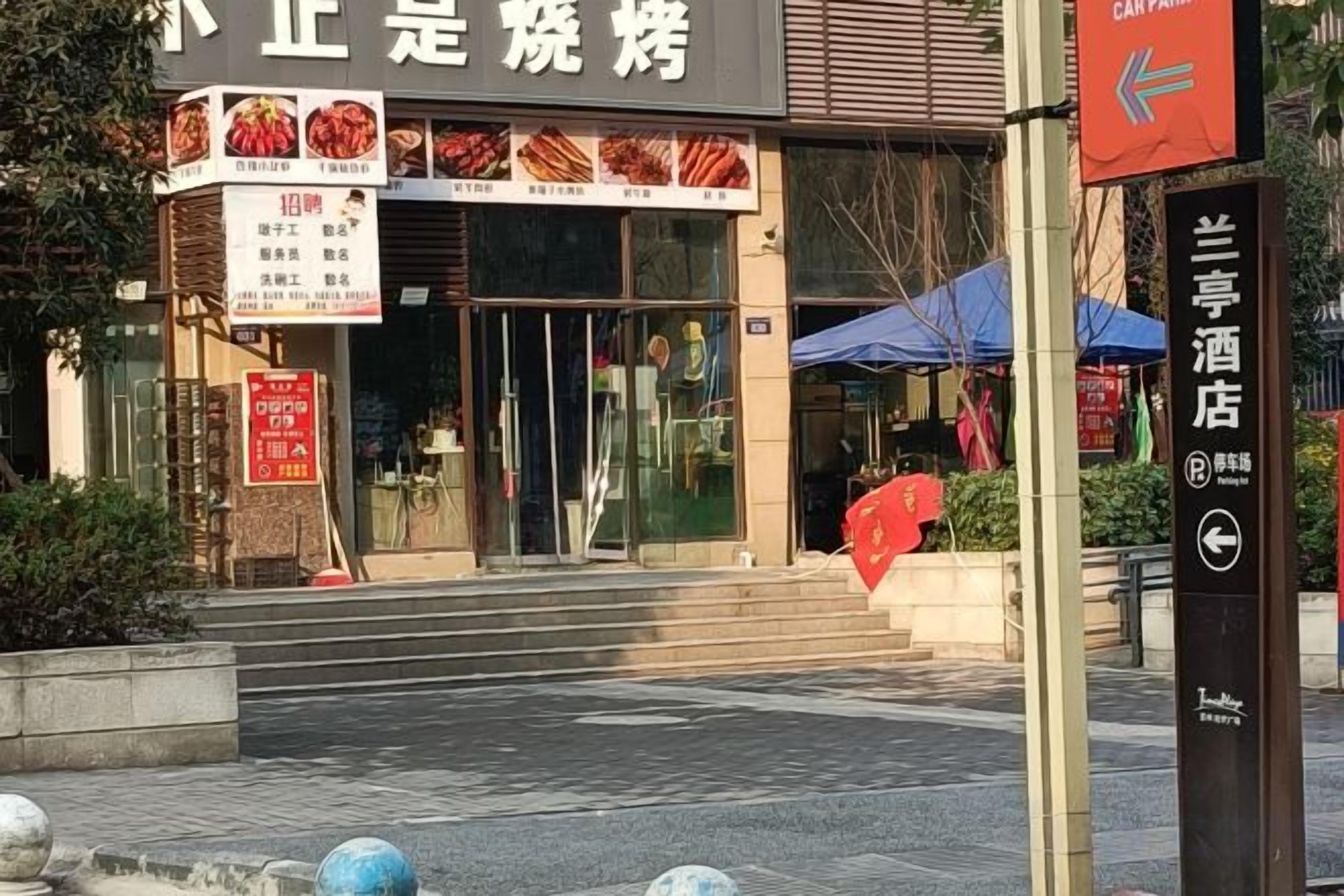 A restaurant with a signboard, a car park sign, and a directional sign.