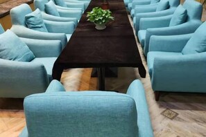 A room with a long table and multiple light blue armchairs arranged around it. - Lanting Culture Theme Hotel (Yingshan)