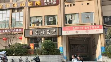 A building with multiple signs, including one for a hotel and another for a parking area.