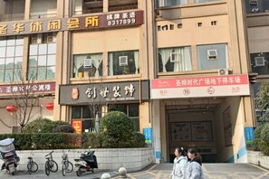 Un edificio con varios carteles, incluyendo uno de hotel y otro para el estacionamiento.