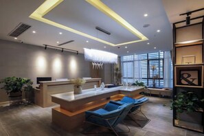 A modern reception area with a reception desk, seating area, and large windows. - Yi She (Chongqing)