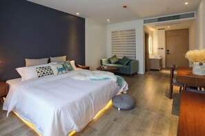 Una camera da letto moderna con un letto grande, comodini, un divano e un tavolo da pranzo in legno.