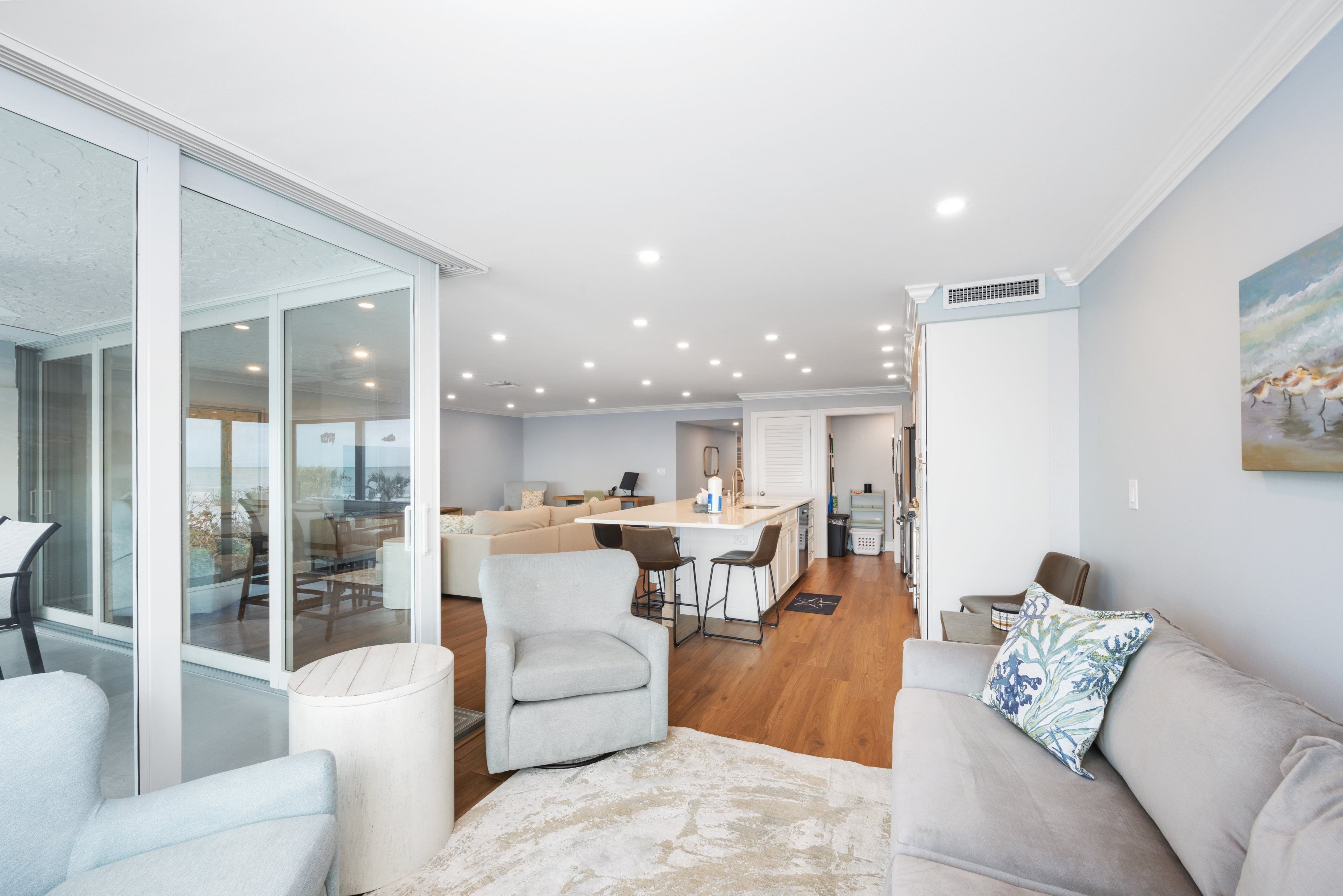 A spacious living area with a sofa, armchairs, and a dining table.
