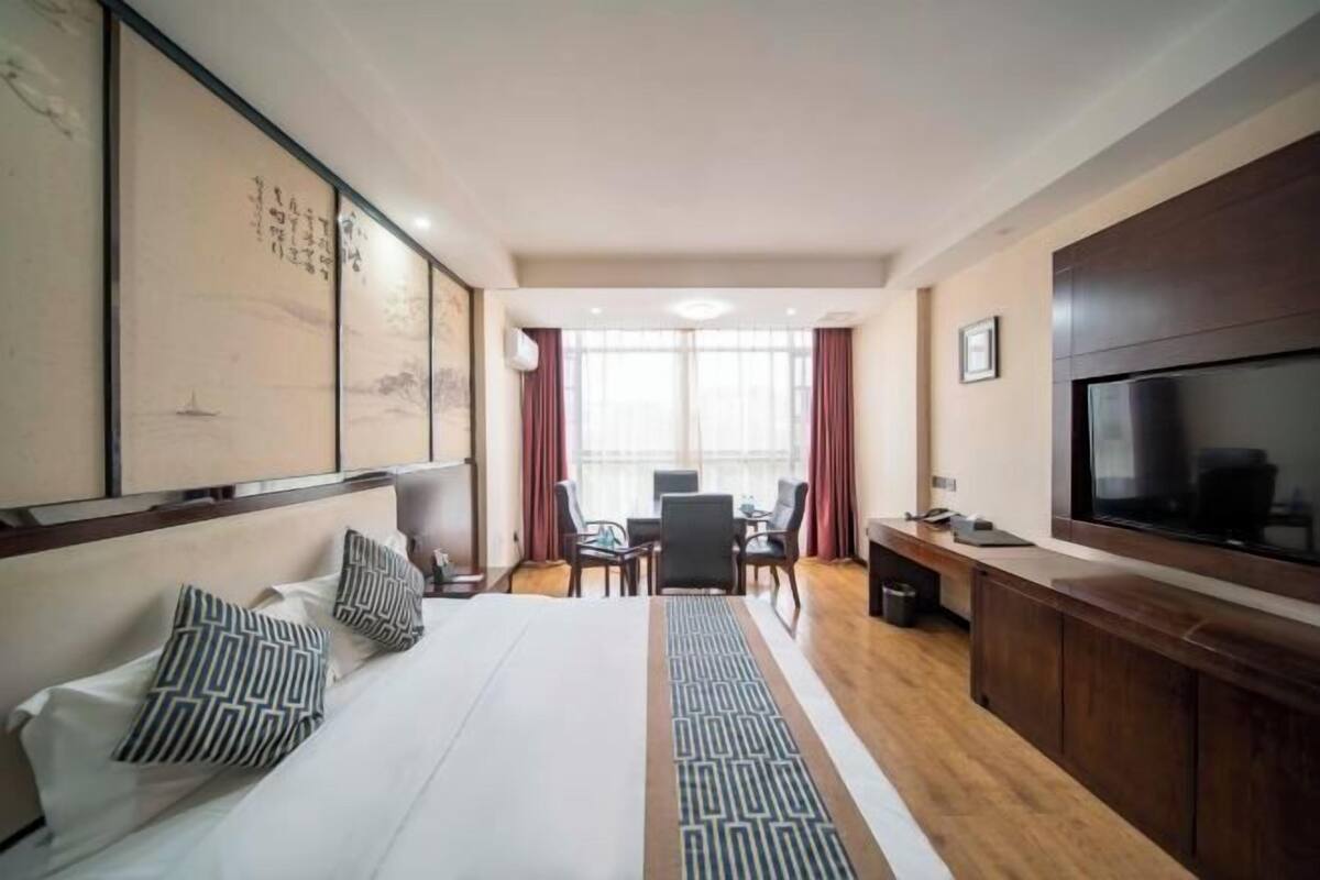 Une chambre d’hôtel équipée d’un lit, d’une télévision, d’un bureau et d’un coin repas.