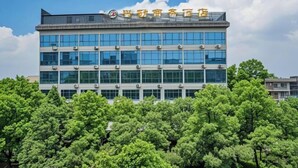 Un edificio a più piani dal design architettonico moderno, caratterizzato da un tetto piatto e ampie finestre.