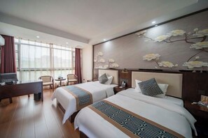A hotel room with two beds, a desk, a chair, and a large window. - Xingdong Business Hotel (Zixing)