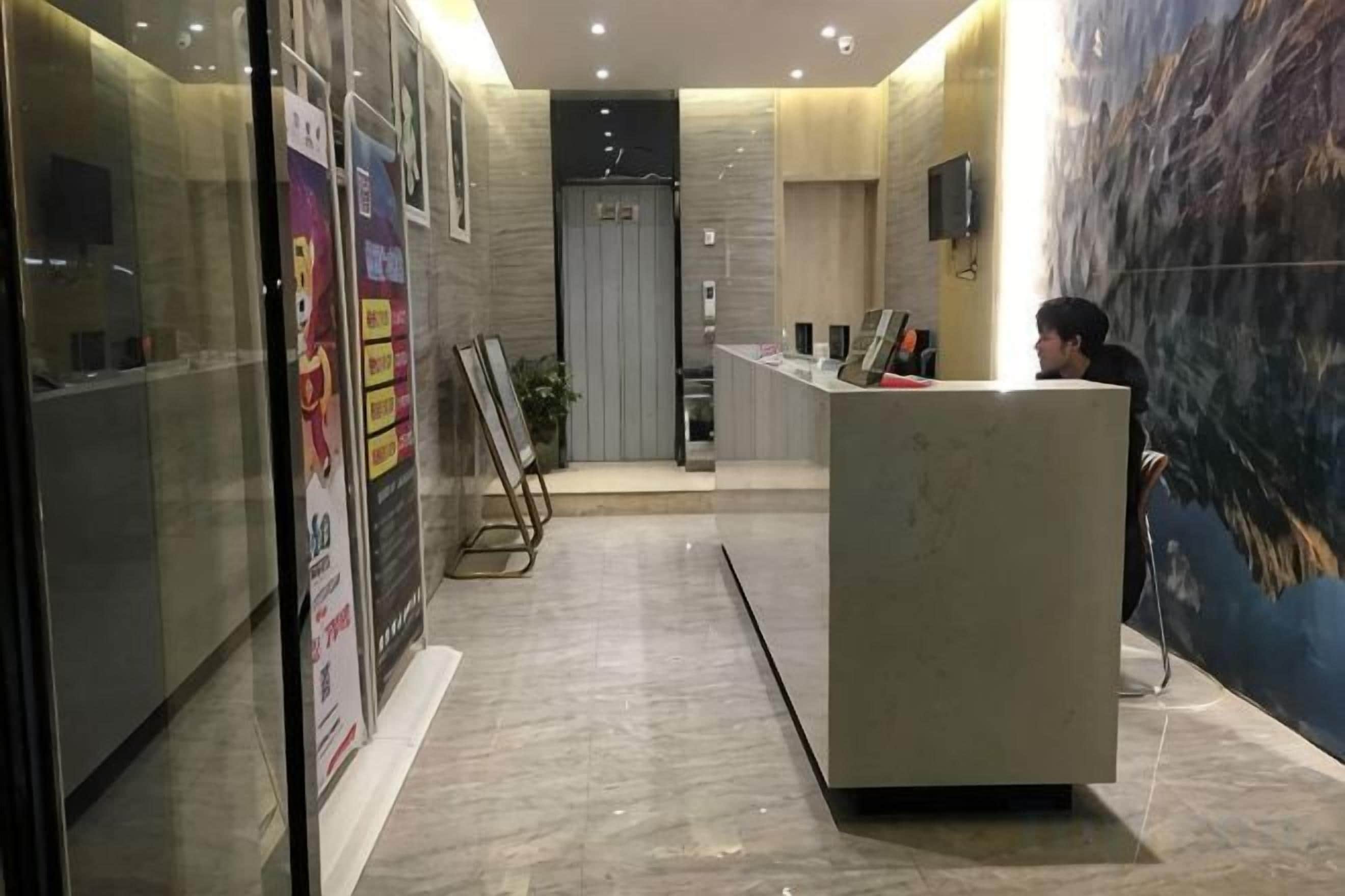 A reception area with a reception desk, a glass wall, and a poster on the wall.