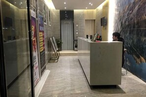 A reception area with a reception desk, a glass wall, and a poster on the wall. - Jasmine Bloom Inn (Xueyuan Road Changjiang University) (Jingzhou)