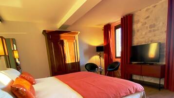 Een hotelkamer met een bed, een televisie, een bureau en een stoel.