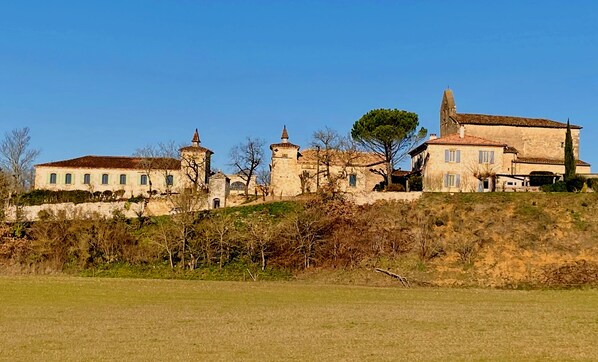 A historic building with multiple structures, including a tower and a large house with a tiled roof. - DOMAINE DE LEJOS - Portes d'Albi (Lamillarie)
