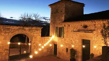 A stone building with a tower, arched entrance, and string lights.