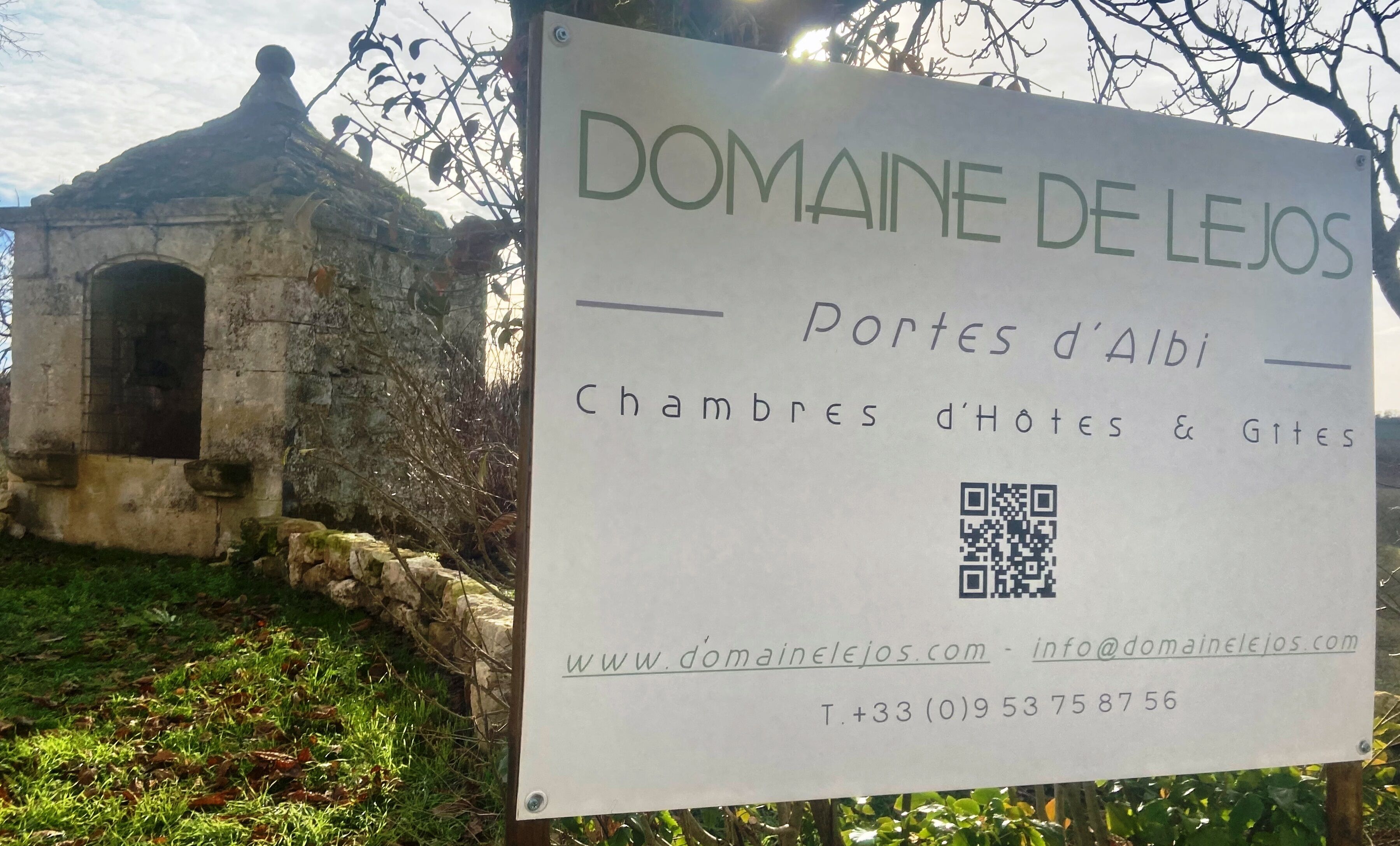 Un panneau indiquant le « Domaine de Lejos », avec une liste des chambres et des lieux à visiter, un code QR et les coordonnées.
