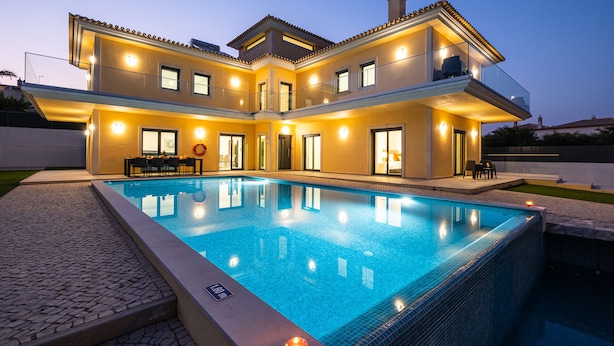 A modern two-story house with a swimming pool, outdoor seating, and a balcony. - Family villa with heatable pool and BBQ (Albufeira)