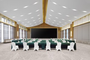 A conference room with multiple tables, white chairs, and a large screen at the front. - Blossom Hill Hotel Ya'an Mengdingshan (Ya'an)