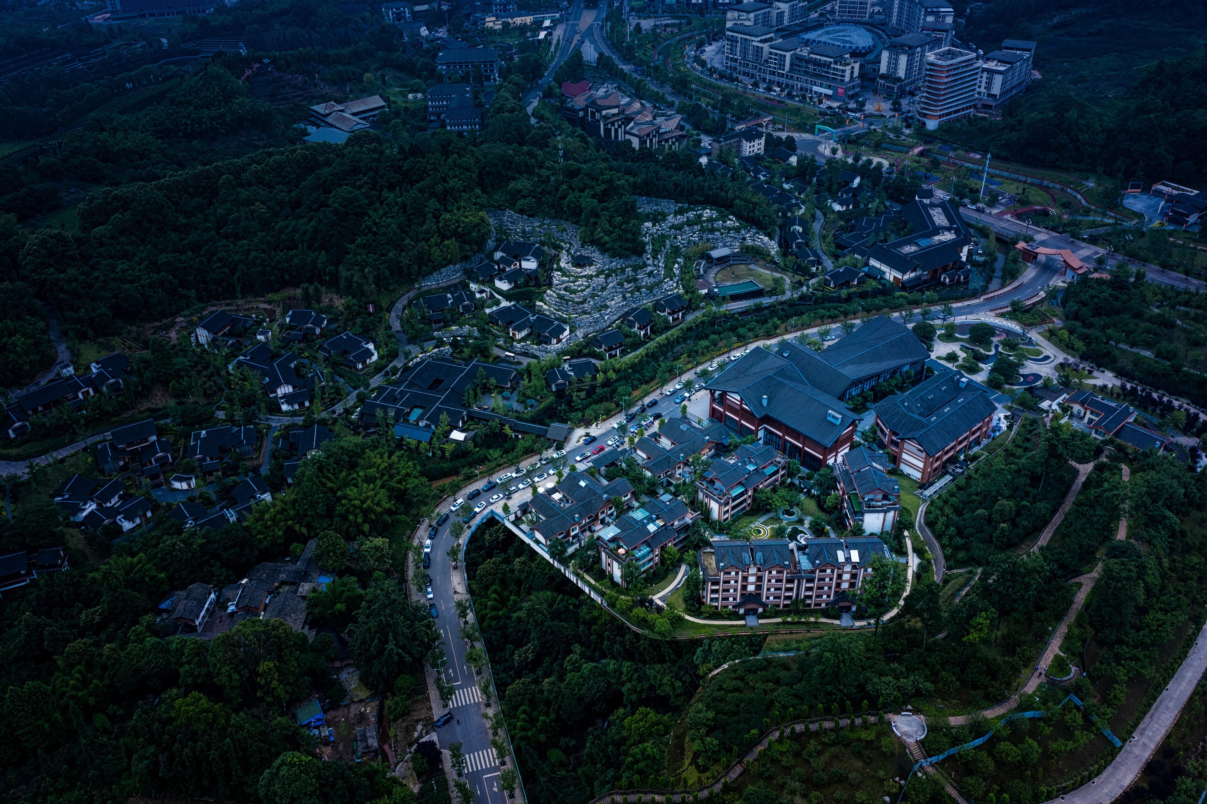 Vista aérea de uma área residencial com vários edifícios, ruas e áreas verdes.