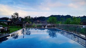 A rectangular swimming pool with a metal railing, surrounded by a grassy area and trees. - Blossom Hill Hotel Ya'an Mengdingshan (Ya'an)