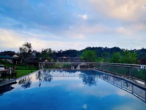 A rectangular swimming pool with a metal railing, surrounded by a grassy area and trees. - Blossom Hill Hotel Ya'an Mengdingshan (Ya'an)