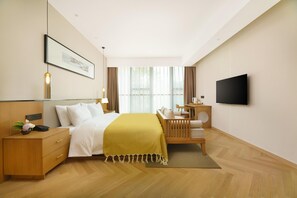 A modern hotel room with a bed, bedside table, lamp, and a flat-screen TV. - Blossom Hill Hotel Ya'an Mengdingshan (Ya'an)