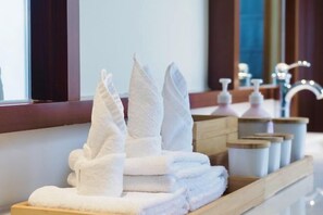 A neatly stacked pile of white towels on a wooden tray in a hotel bathroom. - Blossom Hill Hotel Ya'an Mengdingshan (Ya'an)