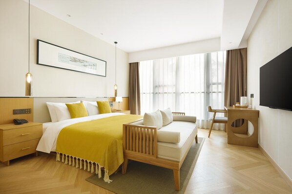A modern hotel room with a large bed, a desk, and a TV. - Blossom Hill Hotel Ya'an Mengdingshan (Ya'an)
